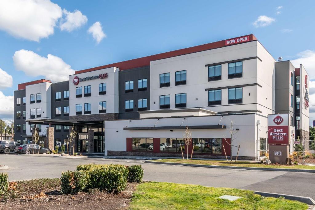 un grand bâtiment blanc avec un parking dans l'établissement Best Western Plus Tacoma Hotel, à Tacoma