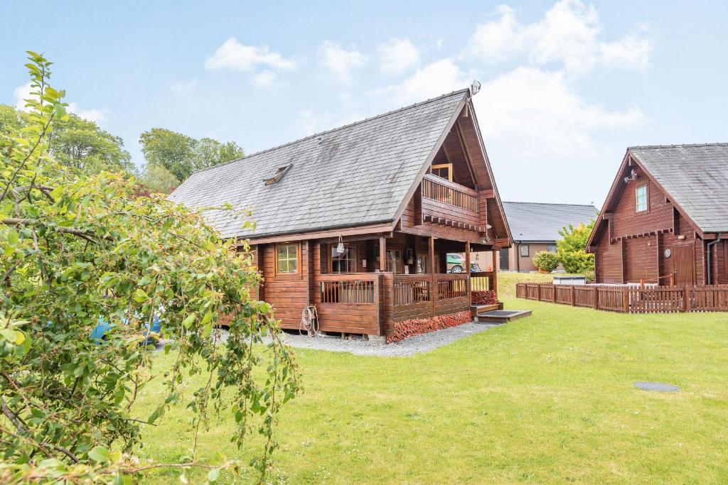 a large wooden house with a yard at Robin Lodge in Llanbedr