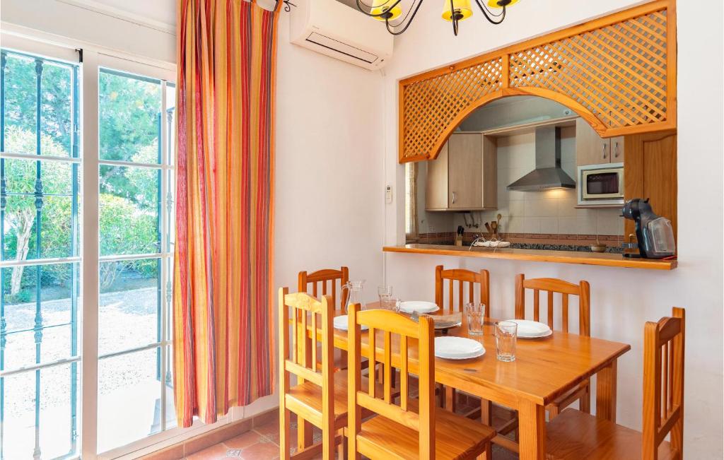 kuchnia i jadalnia z drewnianym stołem i krzesłami w obiekcie Cozy Apartment In Alcaucín With Wifi w mieście Alcaucín