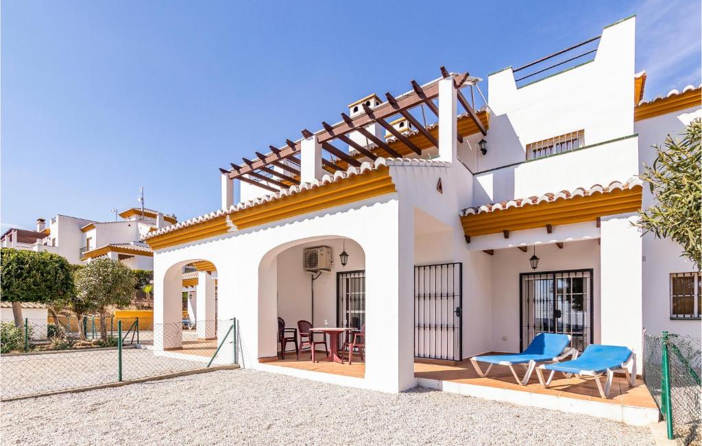 una casa bianca con patio con sedie blu di Gorgeous Apartment In Alcaucn With Kitchen ad Alcaucín