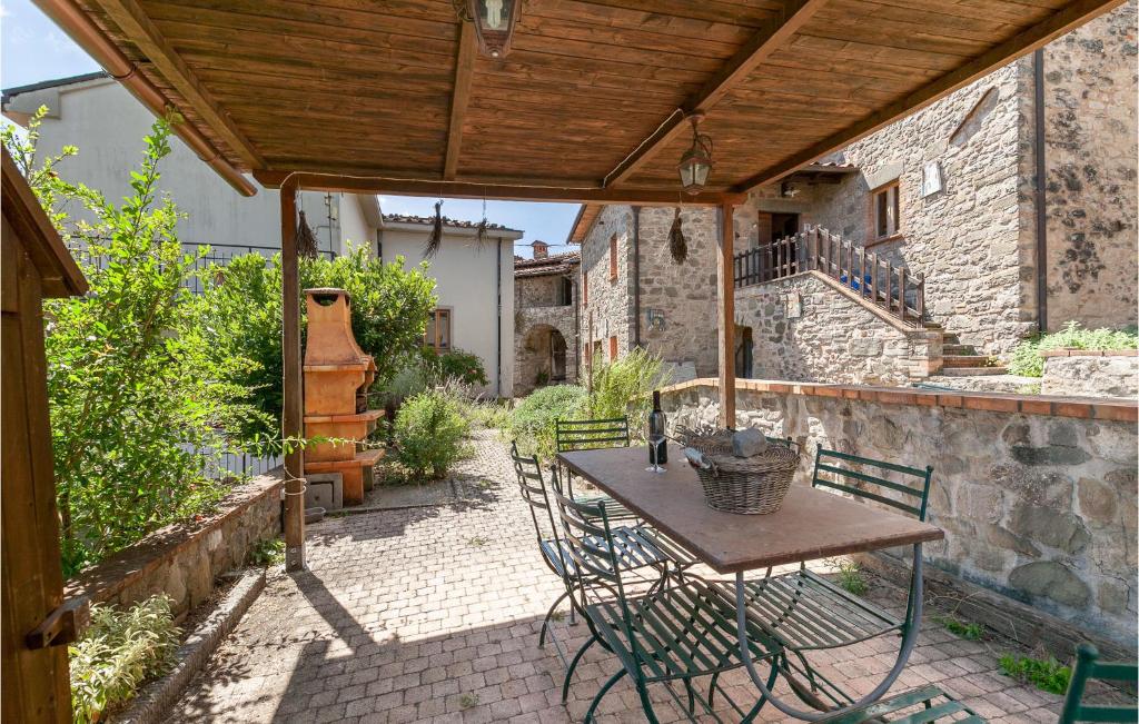 un patio con mesa y sillas bajo un techo de madera en Nice Home In Colognora Di Pescaglia With 4 Bedrooms And Wifi, en Vetriano