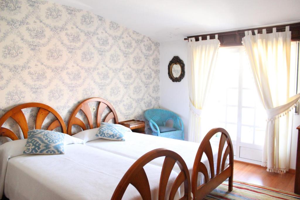 a bedroom with two beds and a window at A Traíña in Cambados