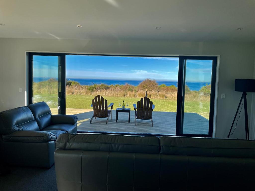 a living room with a couch and a table and chairs at Toko Mouth Beach House in Glenledi