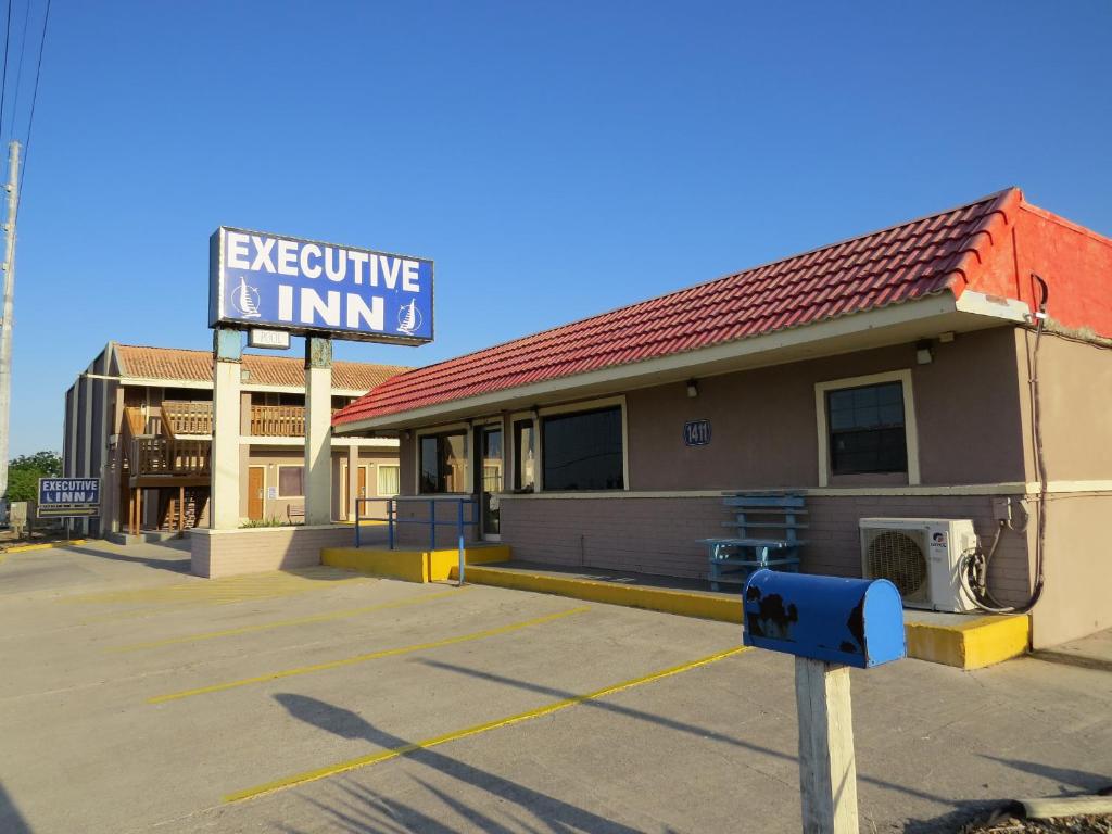 un bâtiment avec un panneau indiquant l'auberge exécutive dans l'établissement Executive Inn Laguna Vista, à Laguna Vista