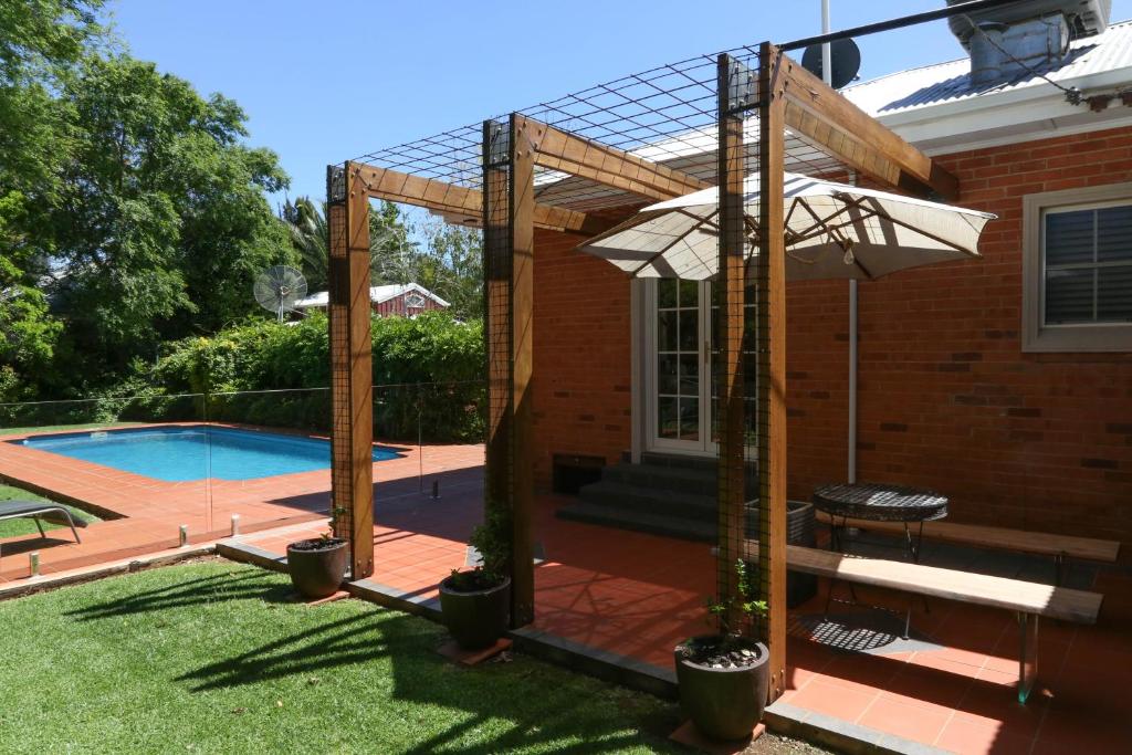 a pergola over a swimming pool in a yard at Le Grange Griffith in Griffith