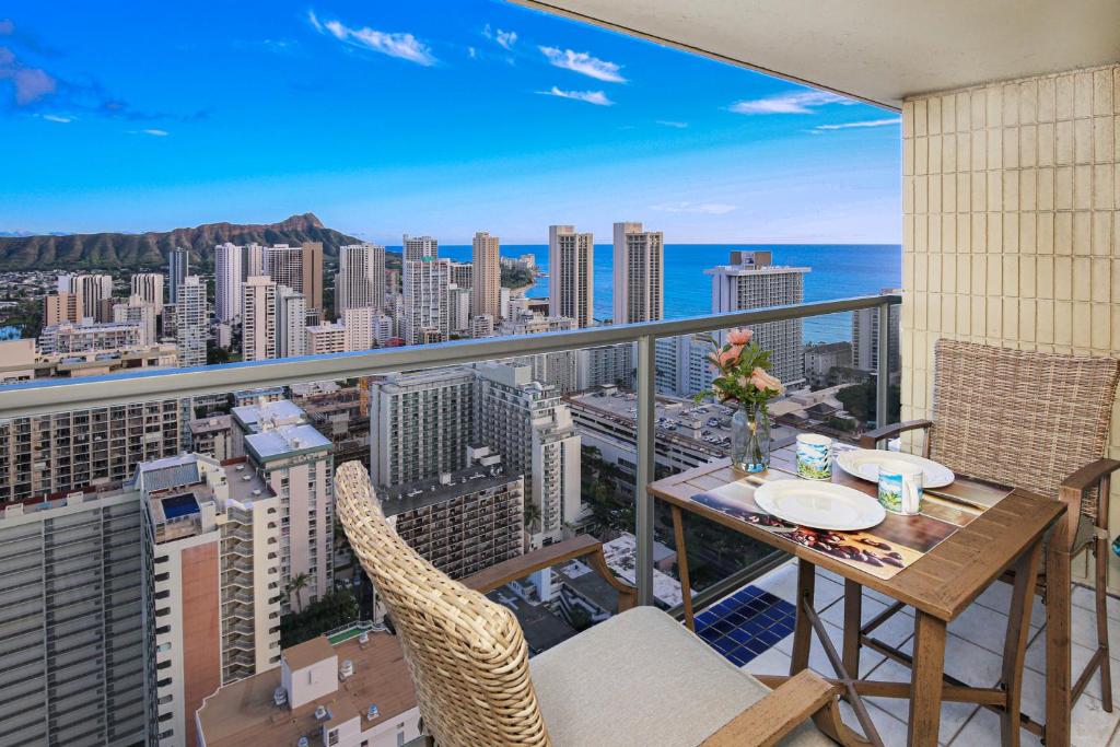 a balcony with a table and chairs and a view of the city at Stylish Studio with Great Ocean Views & Near Beach! in Honolulu