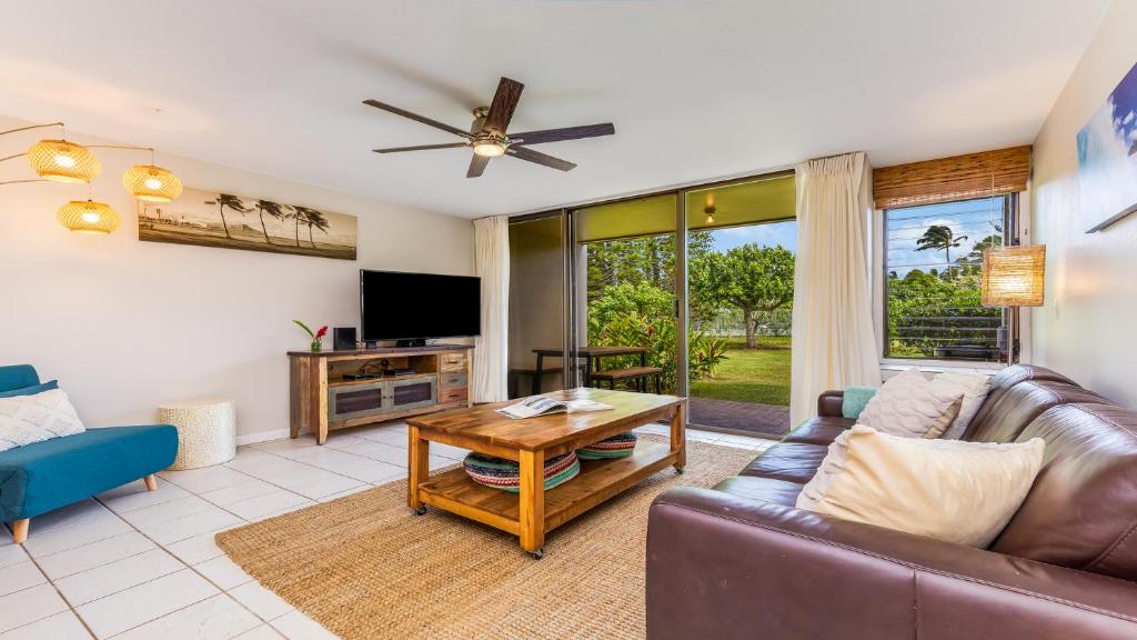 a living room with a couch and a table at Beach Cozy North Shore Turtle Bay Condo in Kahuku