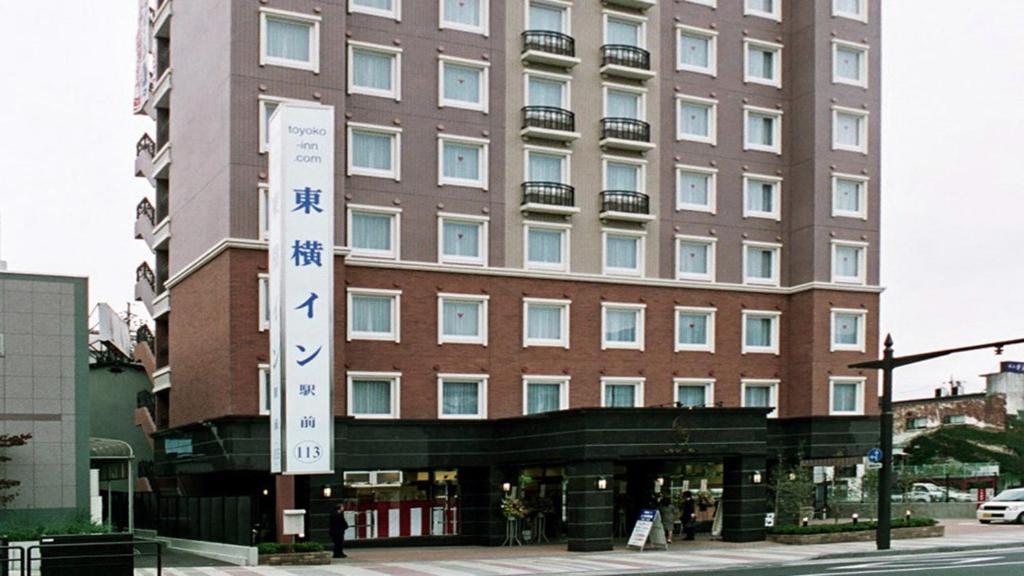 a large building with a sign in front of it at Toyoko Inn Ueda Ekimae in Ueda