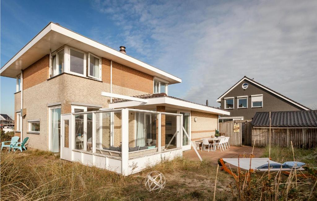 uma casa com portas de vidro deslizantes num quintal em Villa Topduin em Bergen aan Zee