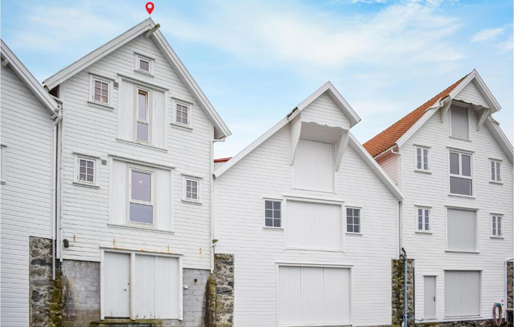 a row of white houses with white doors at Nice Home In Sandve With House Sea View in Sandve