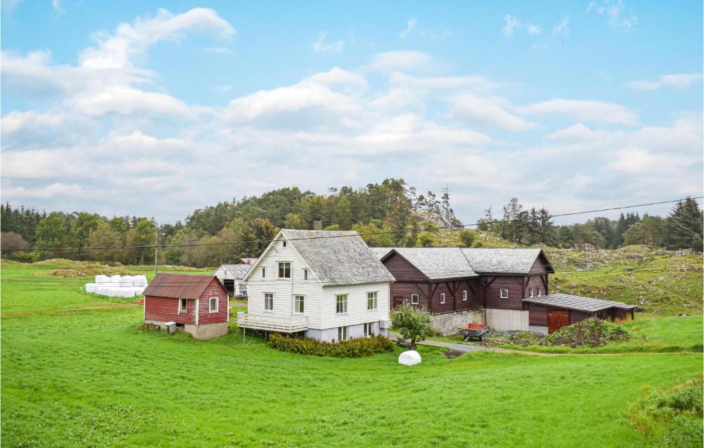 un grupo de casas en un campo verde en Amazing Home In Urangsvg With House A Panoramic View, en Bømlo