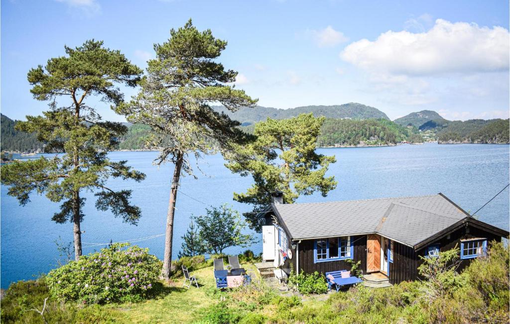 a house on a hill next to a lake at Gorgeous Home In Reksteren With Kitchen in Klinkholmen