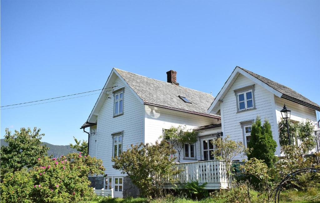 uma casa branca com um alpendre e um telhado em Amazing Home In Hylandsbygd With House Sea View 