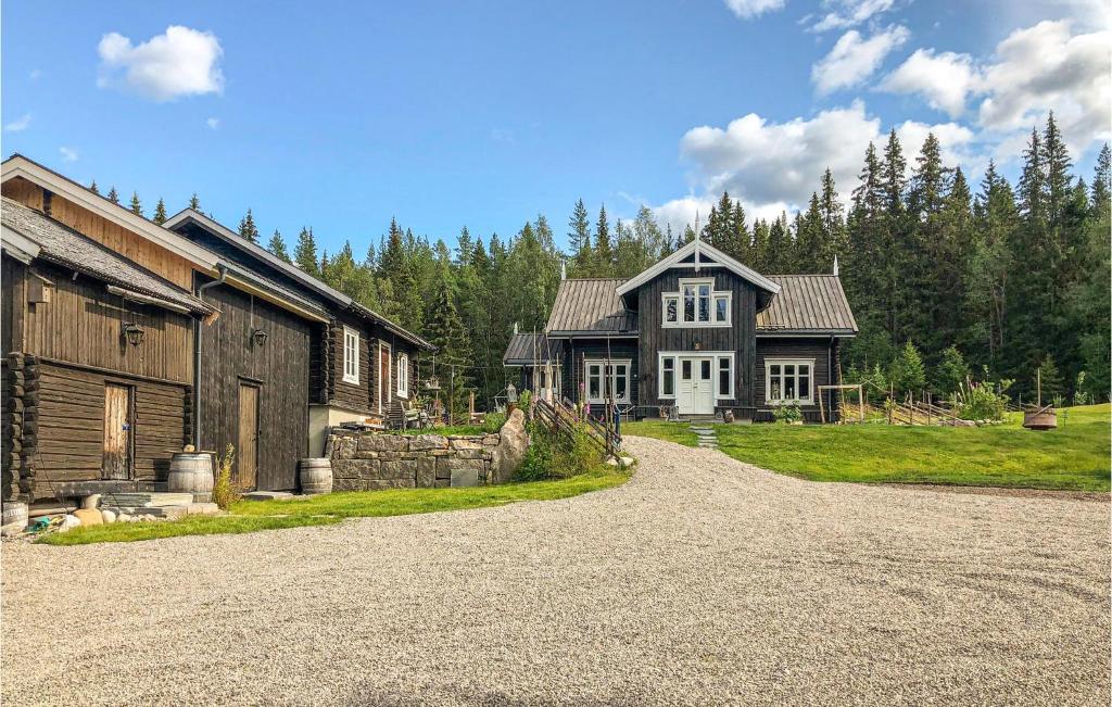 una casa en un camino de tierra al lado de un edificio en Gorgeous Home In Nybergsund With Kitchen, en Nybergsund