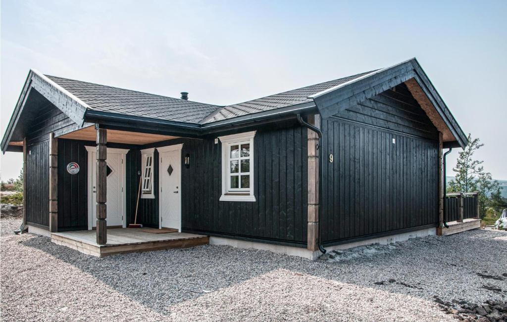 a black shed with a white door and a porch at Beautiful Home In Engerdal With Kitchen 