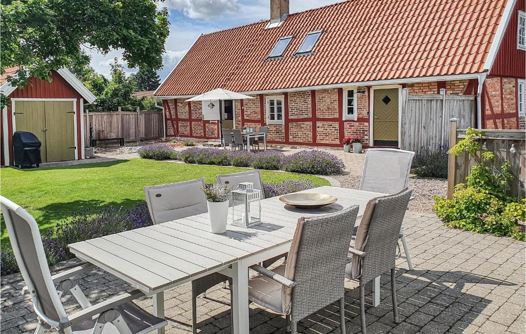 una mesa de madera y sillas en un patio con una casa en 3 Bedroom Awesome Home In Jonstorp en Jonstorp
