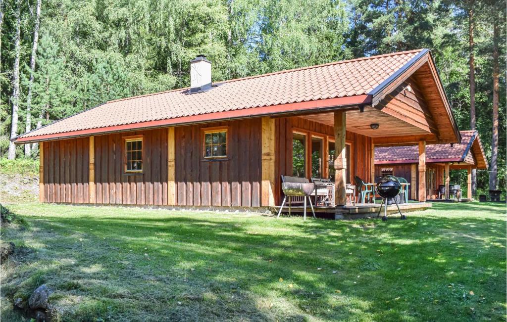 a wooden cabin with a grill in a yard at Bjertnes Turistgrd in Noresund