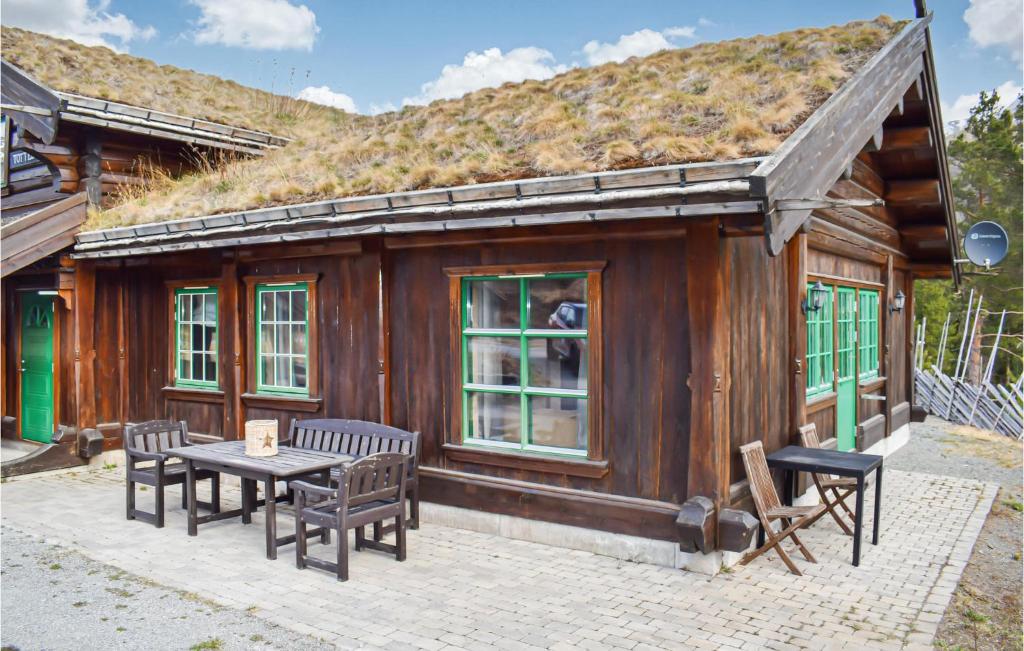 a building with a grass roof with a table and chairs at Lovely Home In Hemsedal With Wifi in Hemsedal