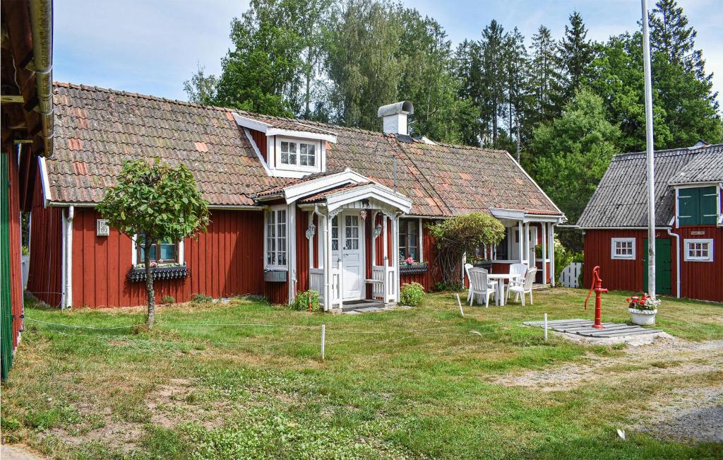 une maison rouge avec une table et des chaises dans la cour dans l'établissement Cozy Home In Hstveda With House A Panoramic View, à Hästveda