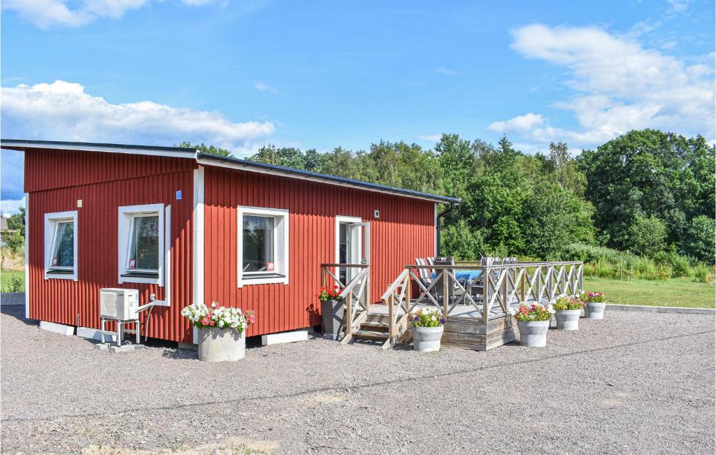 a red house with a porch and a table and chairs at Gorgeous Home In Billesholm With Kitchen in Billesholm