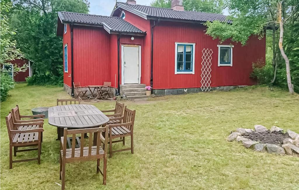 Awesome Home In Bjrnum With Wifi في Bjärnum: كابينة حمراء فيها كراسي وطاولة امامها