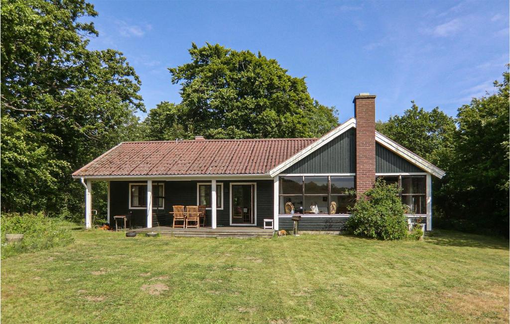 uma pequena casa com uma chaminé de tijolo num quintal em Lovely Home In Brkne-hoby With House Sea View em Bräkne-Hoby