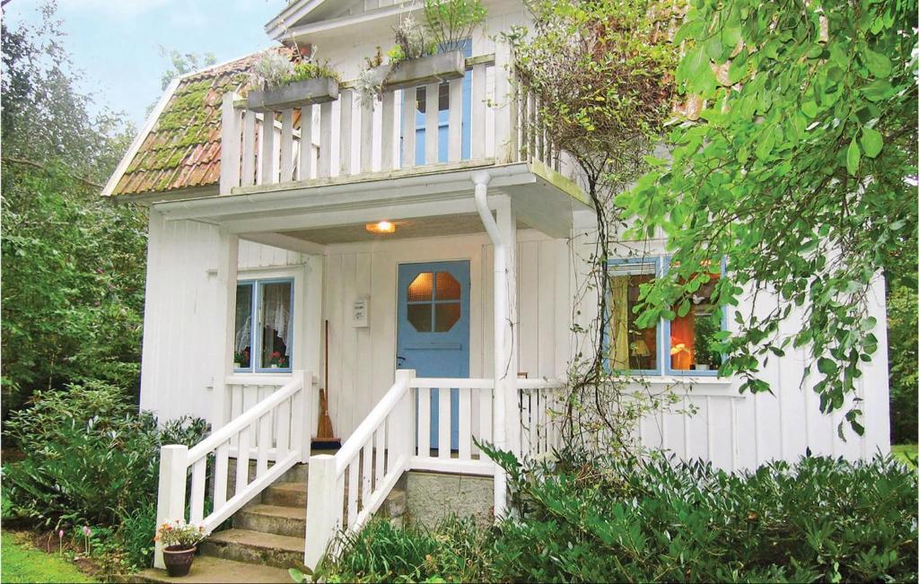 a white house with a blue door and stairs at Awesome Home In Mrbylnga With 2 Bedrooms in Stora Frö