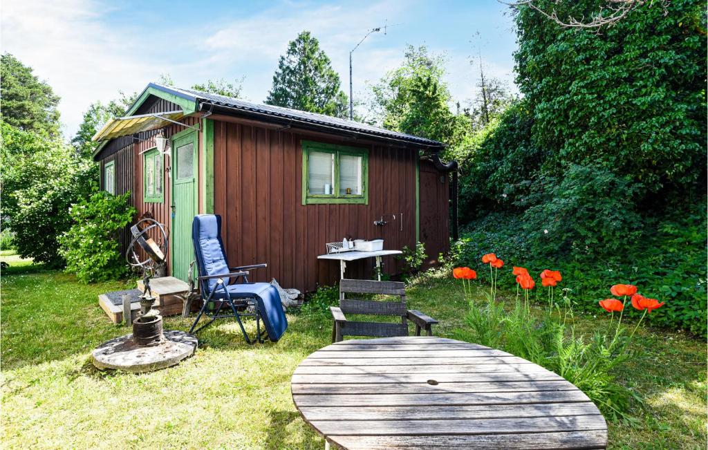uma pequena cabana com uma mesa e cadeiras num quintal em Awesome Home In Slite With Kitchenette em Slite