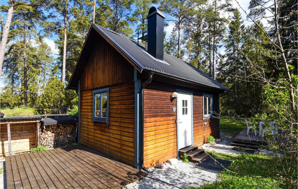 eine kleine Holzhütte mit einer Veranda im Wald in der Unterkunft 1 Bedroom Amazing Home In Slite in Slite