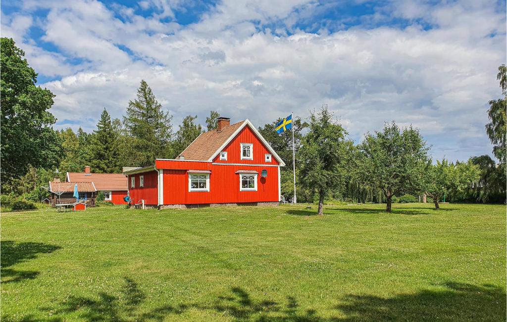 a red house in a field with a kite at Beautiful Home In Mullsj With Kitchen in Mullsjö