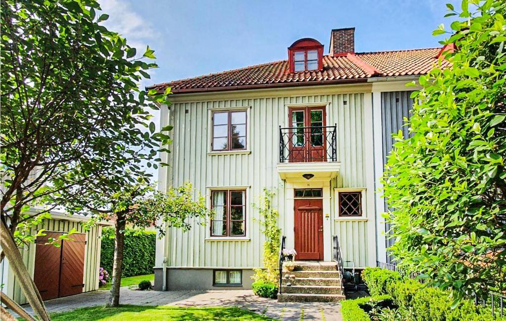 una pequeña casa blanca con una puerta roja en Amazing Home In Gteborg With Wifi, en Gotemburgo