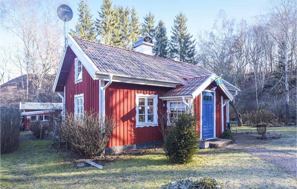 a small red house with a blue door at Stunning Home In Falkping With Kitchen in Falköping