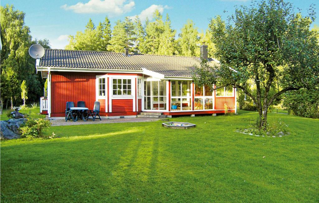 una casa roja con una mesa y sillas en un patio en 3 Bedroom Beautiful Home In Ambjrnarp en Ambjörnarp