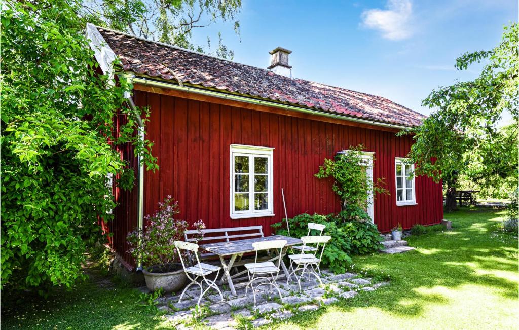 una casa roja con una mesa de picnic delante de ella en Amazing Home In Lidkping With Kitchen, en Lidköping