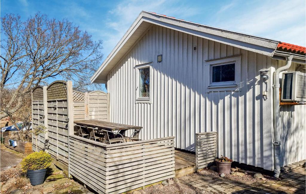 uma pequena casa branca com uma mesa de piquenique no alpendre em Gorgeous Home In Skrhamn With Wifi em Skärhamn