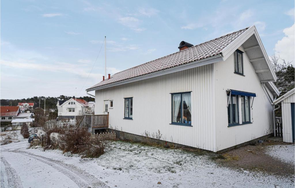 une maison blanche avec de la neige au sol dans l'établissement 4 Bedroom Lovely Home In Grebbestad, à Grebbestad