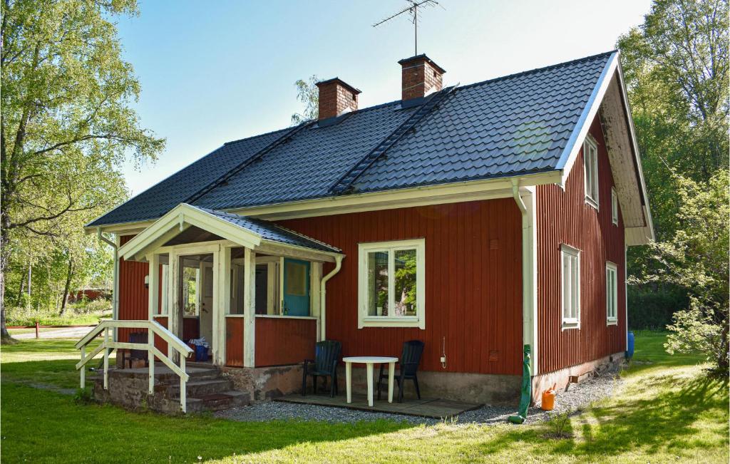 a red house with a table in front of it at Awesome Apartment In Rnneshytta With 1 Bedrooms in Rönneshytta