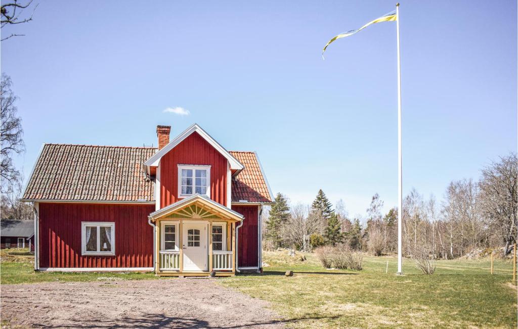 une maison rouge avec un drapeau devant elle dans l'établissement Stunning Home In deshg With Wifi, à Ödeshög
