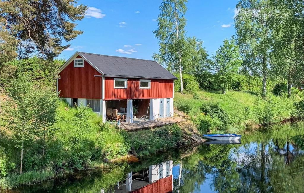 a red house sitting on the side of a river at Amazing Home In Torsby With Wifi in Torsby