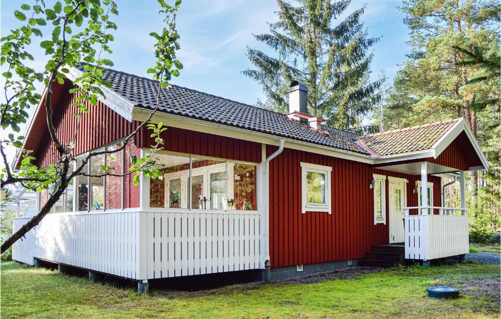 una pequeña casa roja con adornos blancos en Cozy Home In Mariefred With Wifi en Mariefred