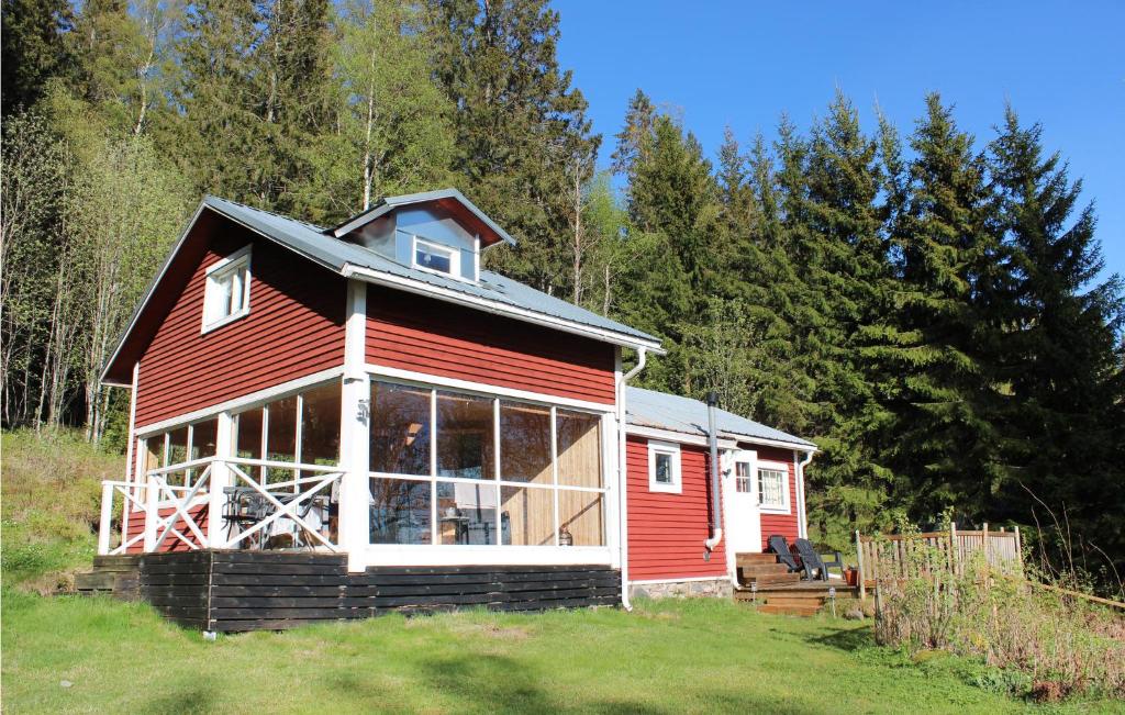 une cabine rouge dans un champ arboré dans l'établissement Beautiful Home In Bovik With Wifi, 