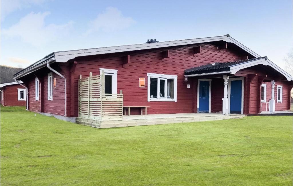 ein rotes Haus mit einem grünen Feld davor in der Unterkunft Cozy Apartment In Sysslebck With Wifi in Sysslebäck