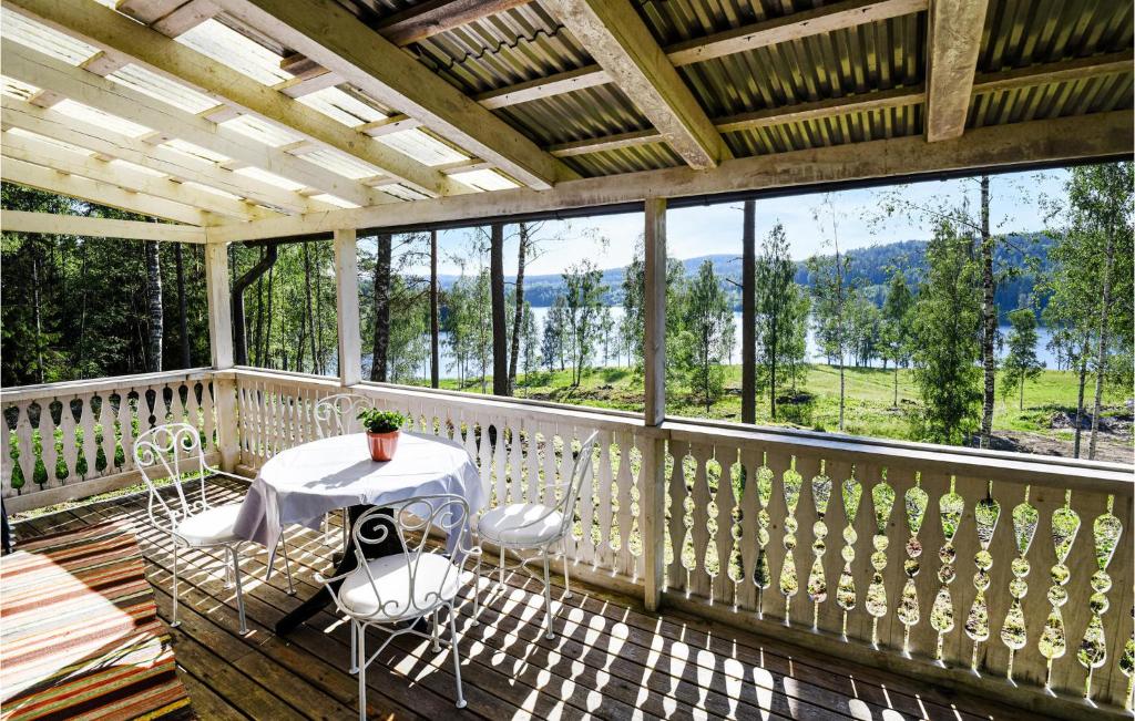un porche con mesa y sillas en 1 Bedroom Awesome Home In motfors en Åmotsfors