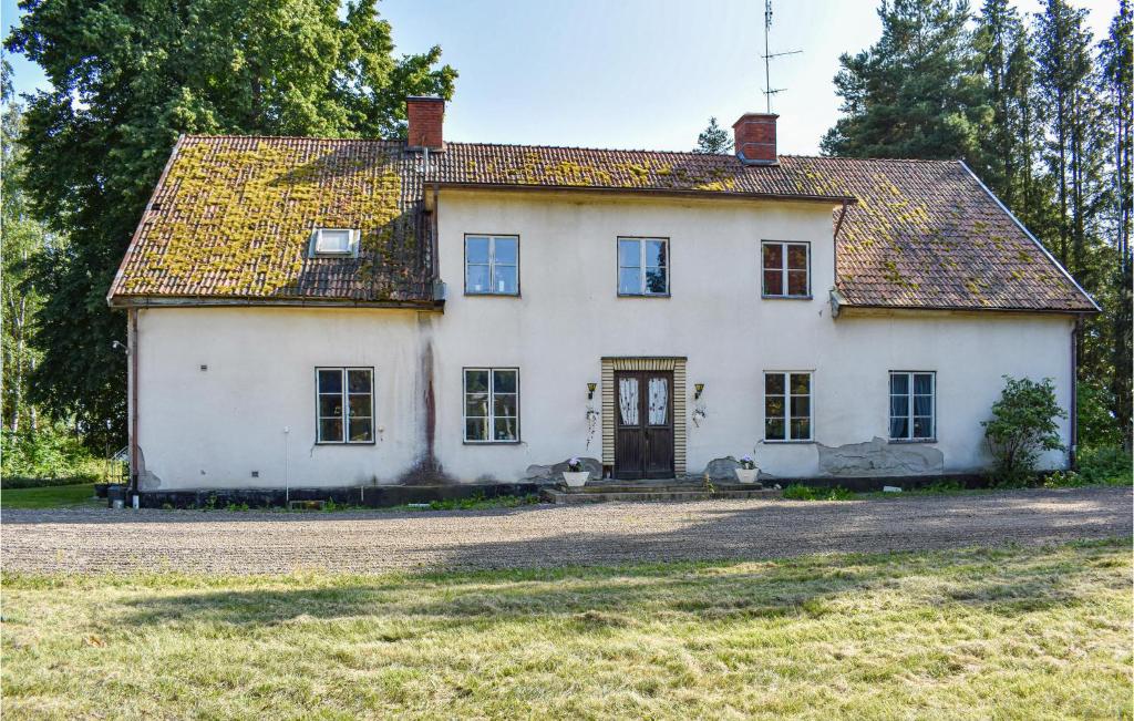 una antigua casa blanca con un gran patio en Amazing Home In Klockrike With Wifi en Klockrike