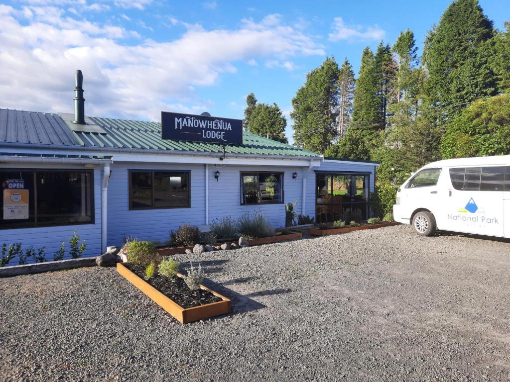 una furgoneta blanca estacionada frente a un edificio en Manowhenua Lodge en National Park