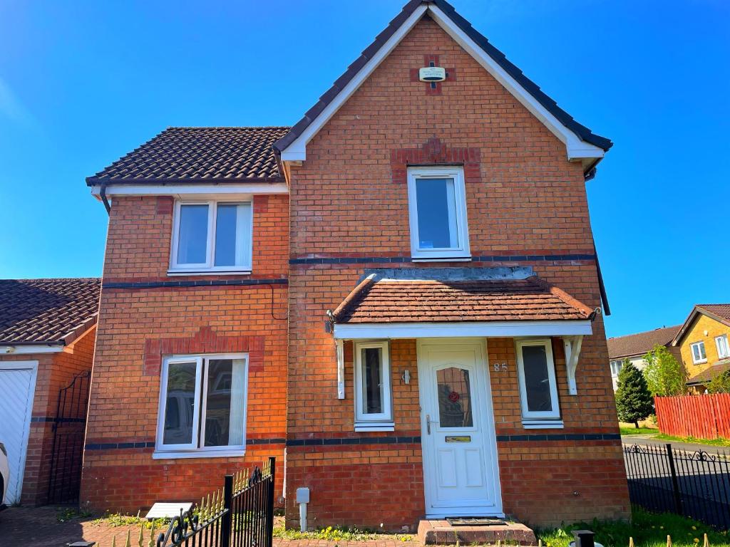 a red brick house with a white door at Cozy Nights SVP Detached House in Nitshill
