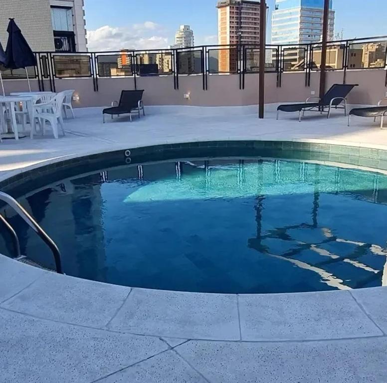 uma piscina no telhado de um edifício em FLAT no Gonzaga com estacionamento incluso em Santos