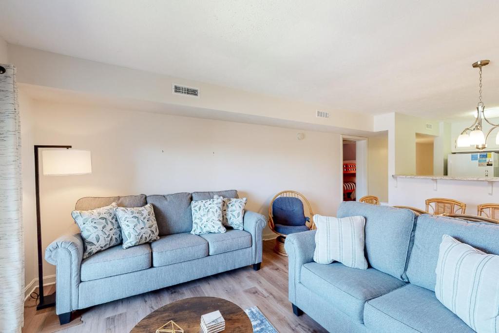 una sala de estar con 2 sofás azules y una mesa. en Bammers Beach Spot OS26, en Corolla