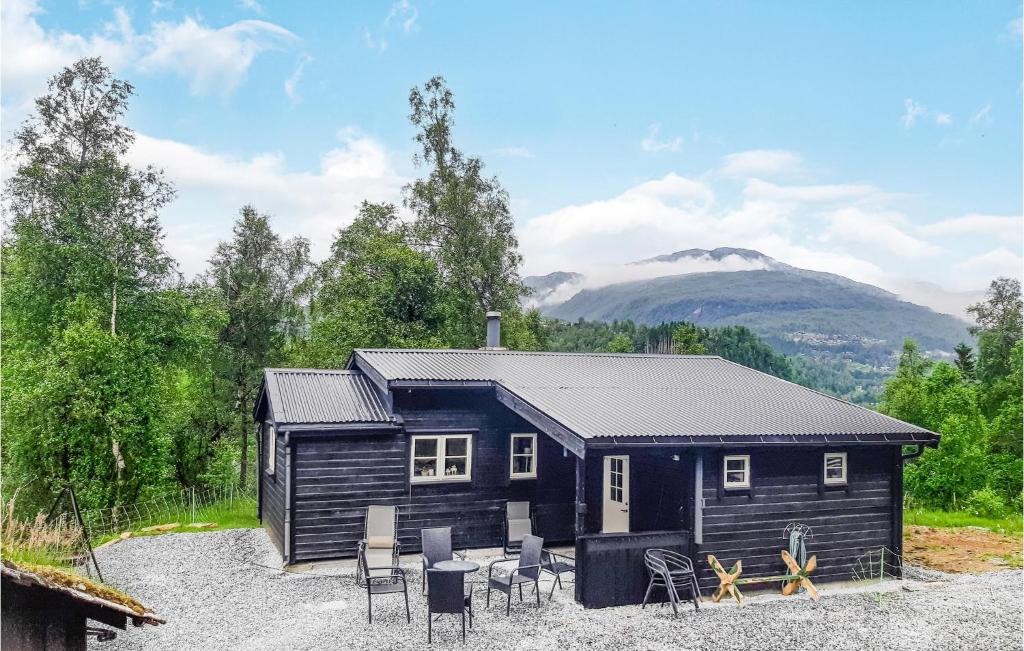 eine schwarze Hütte mit einem Tisch und Stühlen in der Unterkunft Lovely Home In Norheimsund With Wifi in Norheimsund