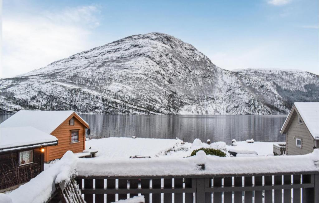 ein Haus im Schnee mit einem Berg im Hintergrund in der Unterkunft 3 Bedroom Beautiful Home In Eikefjord in Eikefjord
